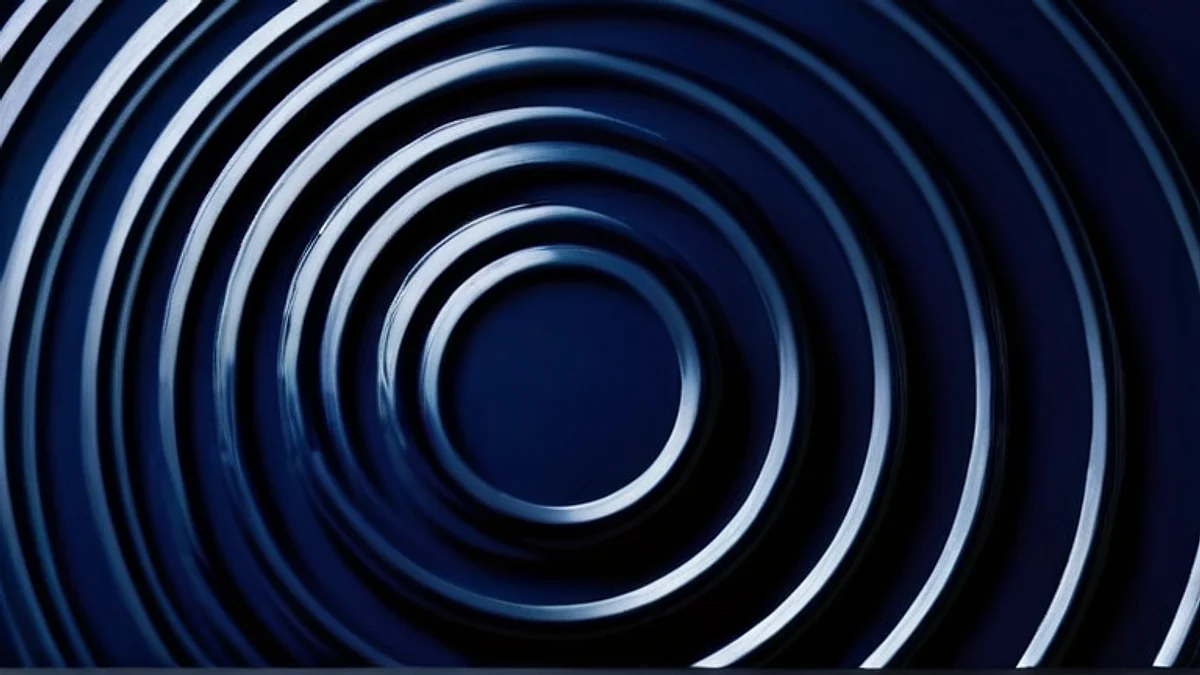Concentric ripples spreading across dark blue water, seen from above.